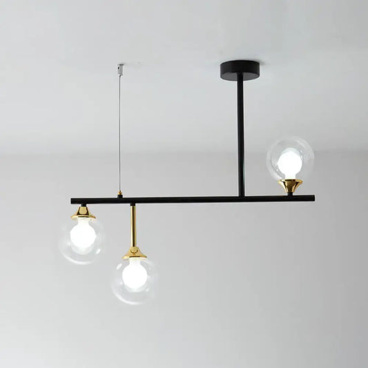 Modern black and gold globe pendant light with three clear glass bulbs in black metal fixture for dining room pendant light fixture