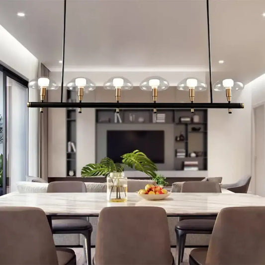 Modern black linear pendant light with five gold fixtures and clear glass shades for restaurant use by decorbites