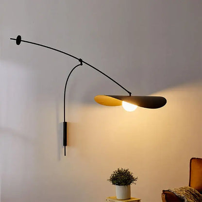 Modern black and gold leaf led wall lamp with glass shade and curved arm featuring warm golden interior for bedroom use