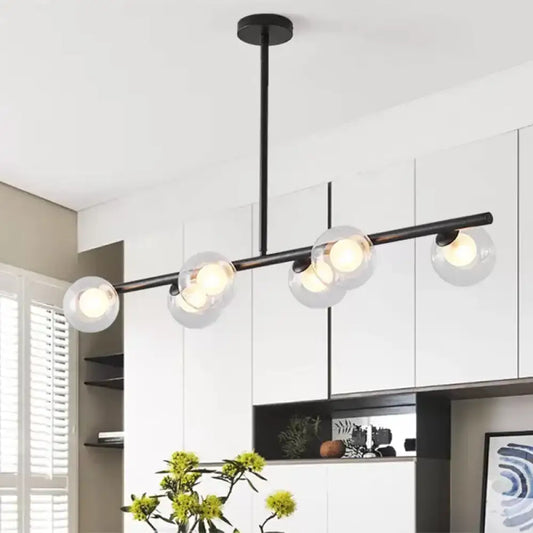 Modern black metal chandelier with five clear glass globe shades featuring light bulbs for dining table illumination