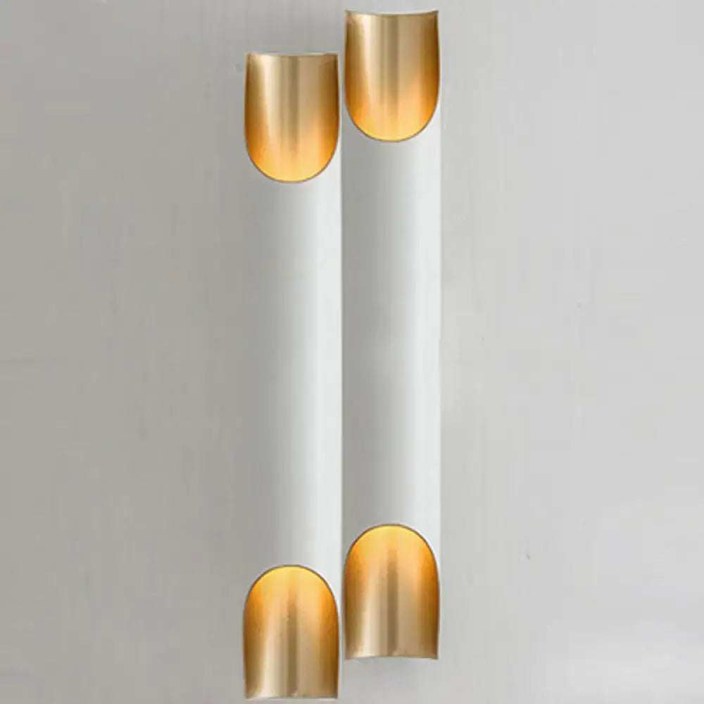 Modern black and gold tubular aluminum wall sconce with white cylindrical body and gold nail-shaped caps for living room