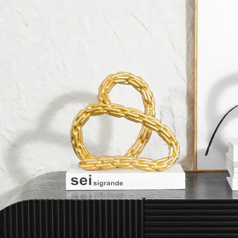 Modern black and golden knot chain sculpture featuring a twisted golden knot chain design for living room decor
