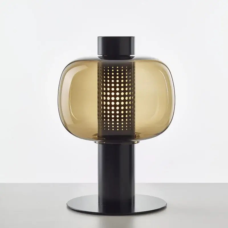 A modern amber glass table light with a black metal perforated base for bedroom decorbites glass table light