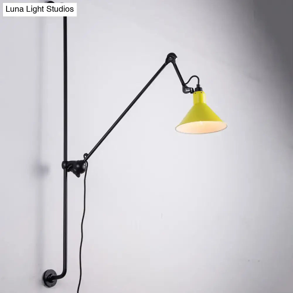 Yellow conical shade wall-mounted lamp with black articulated arm and pipe base for direct wired electric use