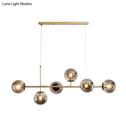 Modern brass pendant light with five smoked glass shade globe bulbs for black and white linear island dining room