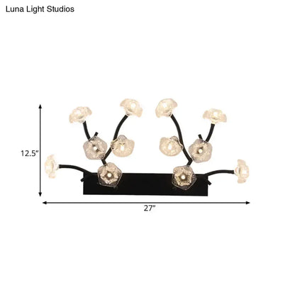 Modern black metal wall light with delicate branching arms and blossom clear glass flower-shaped fixtures for bedroom