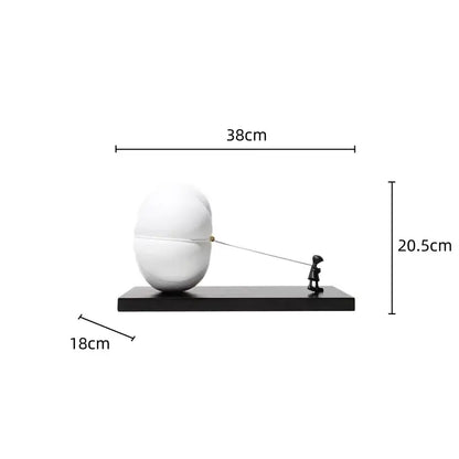 White glossy resin cartoon balloon man sculpture pulling string on oversized egg shaped object for living room decor
