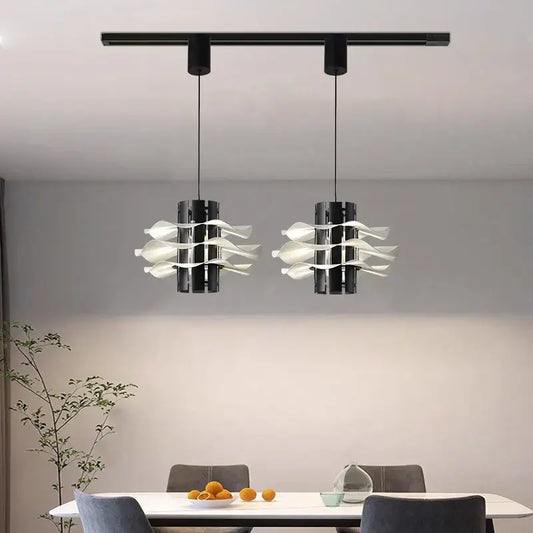 Two modern black pendant lamps with white petal glass shades hang from a track in a designer restaurant pendant decorbites setup