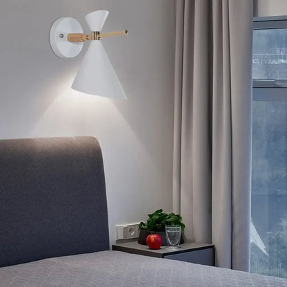 Modern white conical wall sconce with wooden accent arm and black angle shade ideal for bedroom lighting