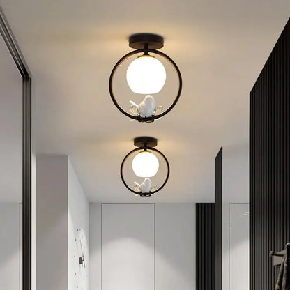 Modern black bird ceiling light fixture with white spherical bulb and delicate bird figurine for corridor entrance