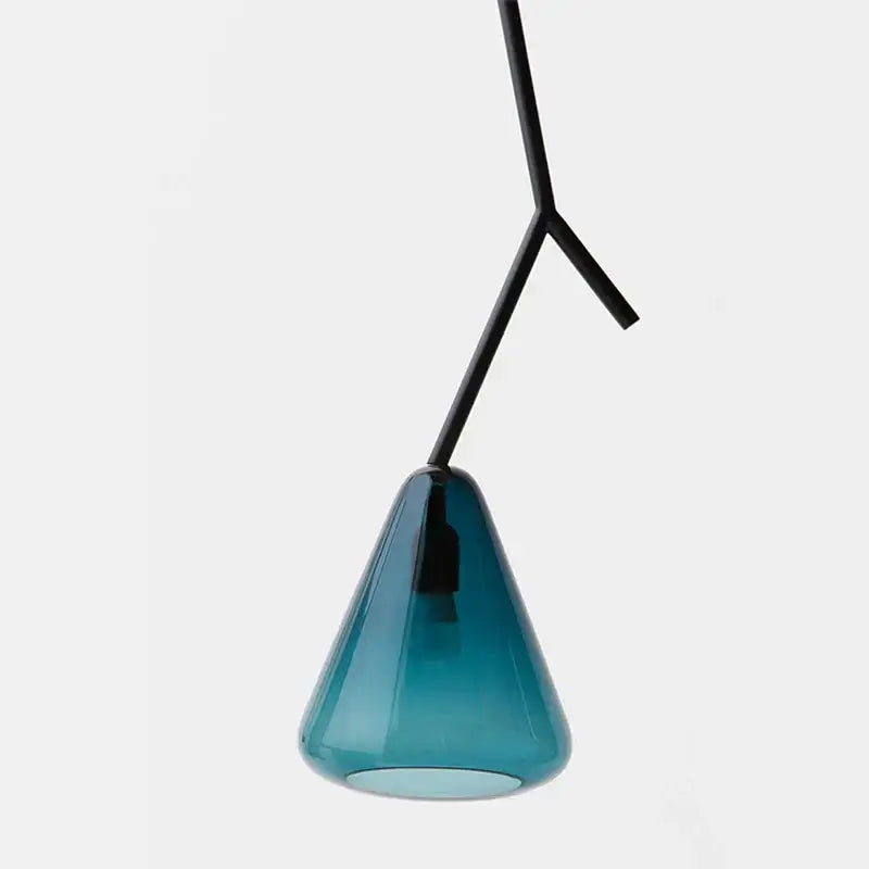 A sleek translucent teal glass pendant light with a minimalist black metal y-shaped suspension arm for dining rooms