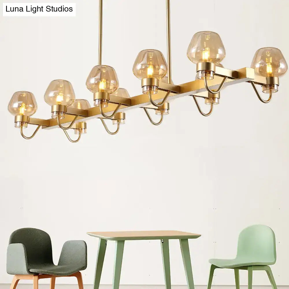 Gold-toned modern chandelier with six amber glass globes and sleek metal frame for contemporary island lighting 110v-120v
