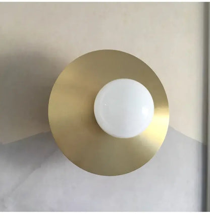 Modern black and brass wall sconce with a golden glass ball globe by decorbites for elegant bedroom lighting decor
