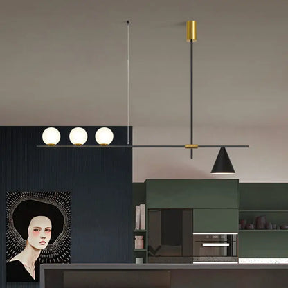 Modern black and brass linear chandelier with three spherical white glass bulbs and a sleek metal frame for dining room