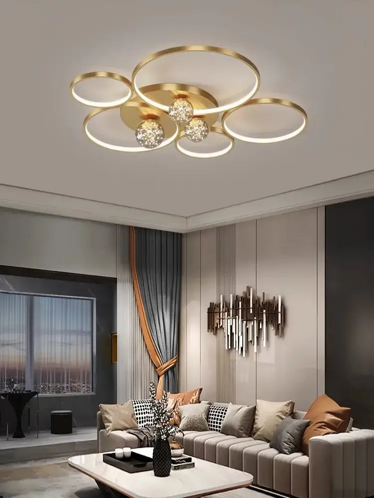 Gold-toned modern ceiling light fixture with interconnected rings and crystal globe bulbs decorbites gypsophila chandelier