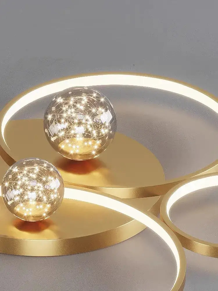Modern black and chrome decorbites gypsophila chandelier with gold-toned circular led light fixtures and star-like glowing orbs