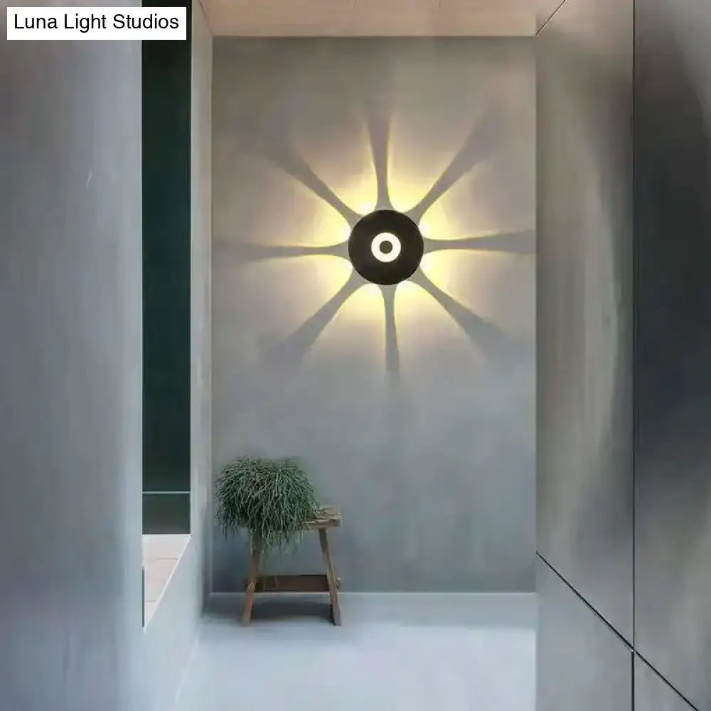 Modern black circular led outdoor wall sconce with sunburst light pattern for stylish outdoor wall lighting