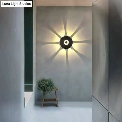 Modern black circular led outdoor wall sconce with sunburst light pattern for stylish outdoor wall lighting