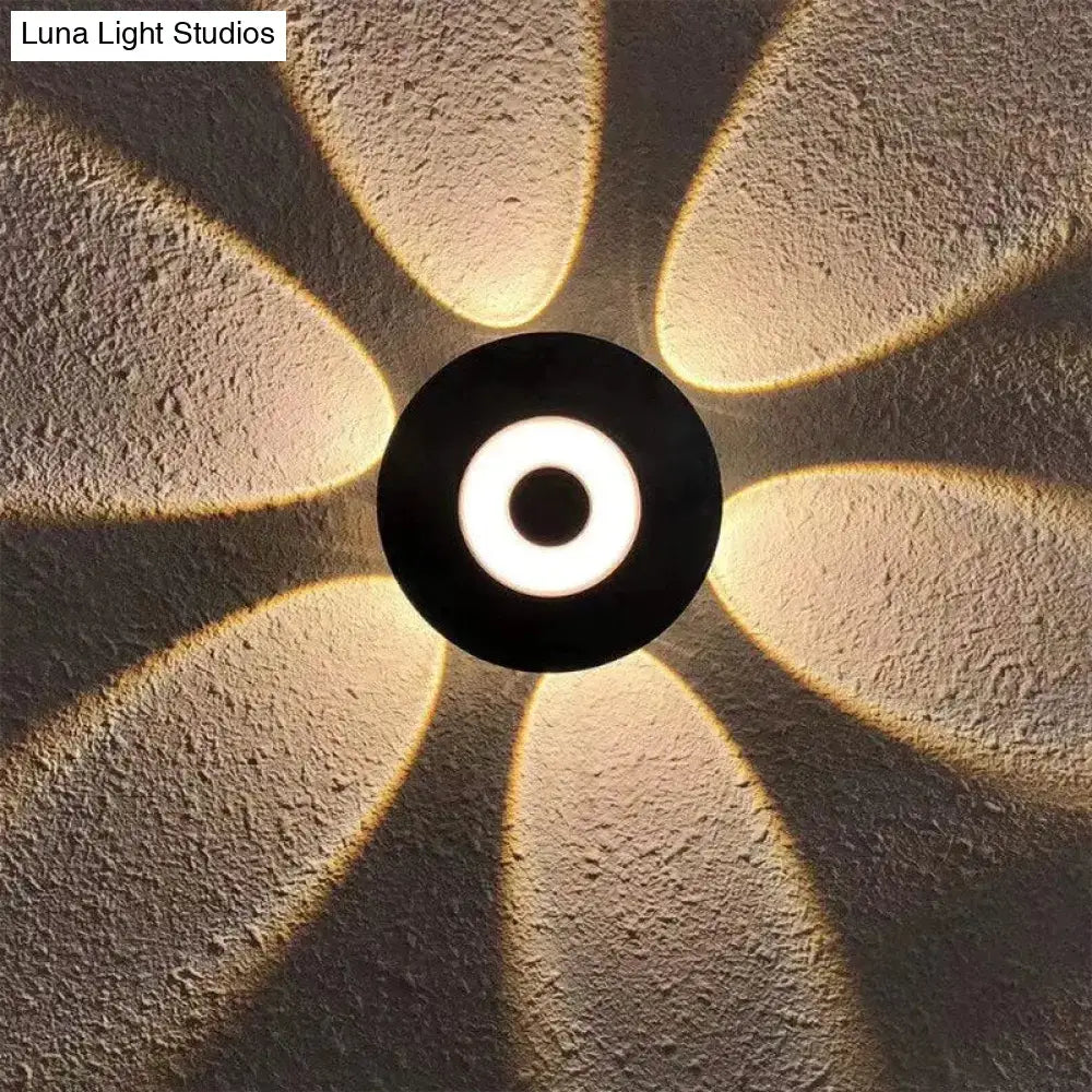 Modern black circular led outdoor wall sconce with glowing white ring and warm petal-shaped light for outdoor wall use