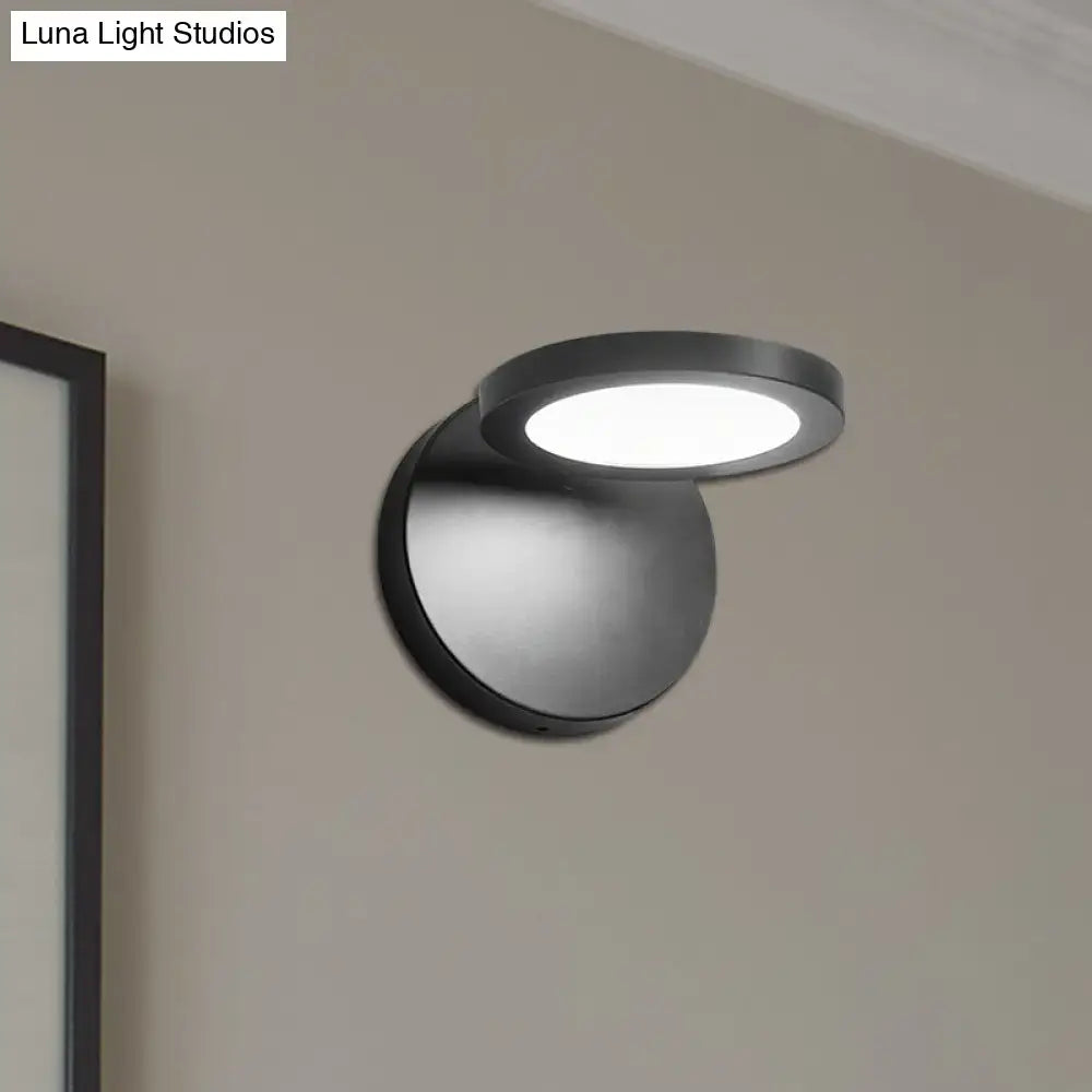 Modern black circular wall lamp with frosted glass diffuser providing white warm lighting for bedroom use