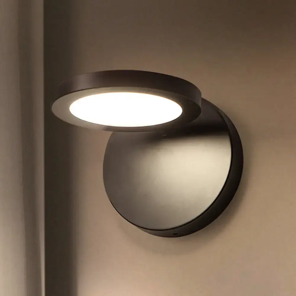 Modern black circular wall lamp with frosted glass diffuser providing white warm lighting for bedroom use
