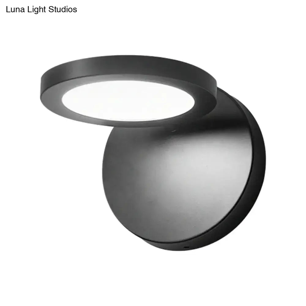 Modern black circular wall lamp with frosted glass diffuser providing white warm lighting for bedroom use