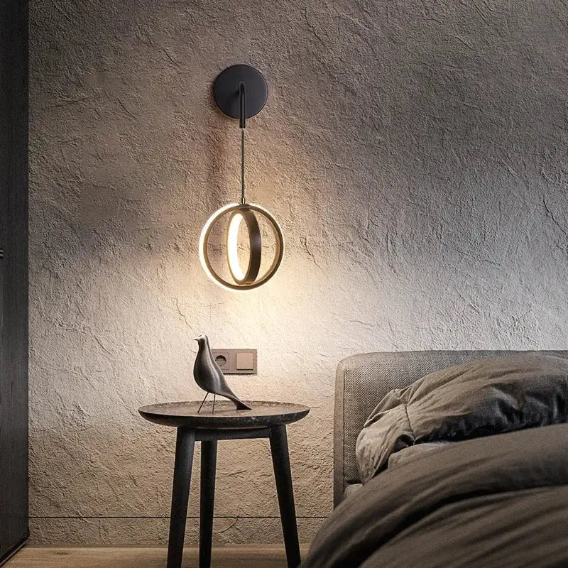 Modern black circular wall sconce light featuring a glowing ring light ideal for bedroom wall sconce lighting