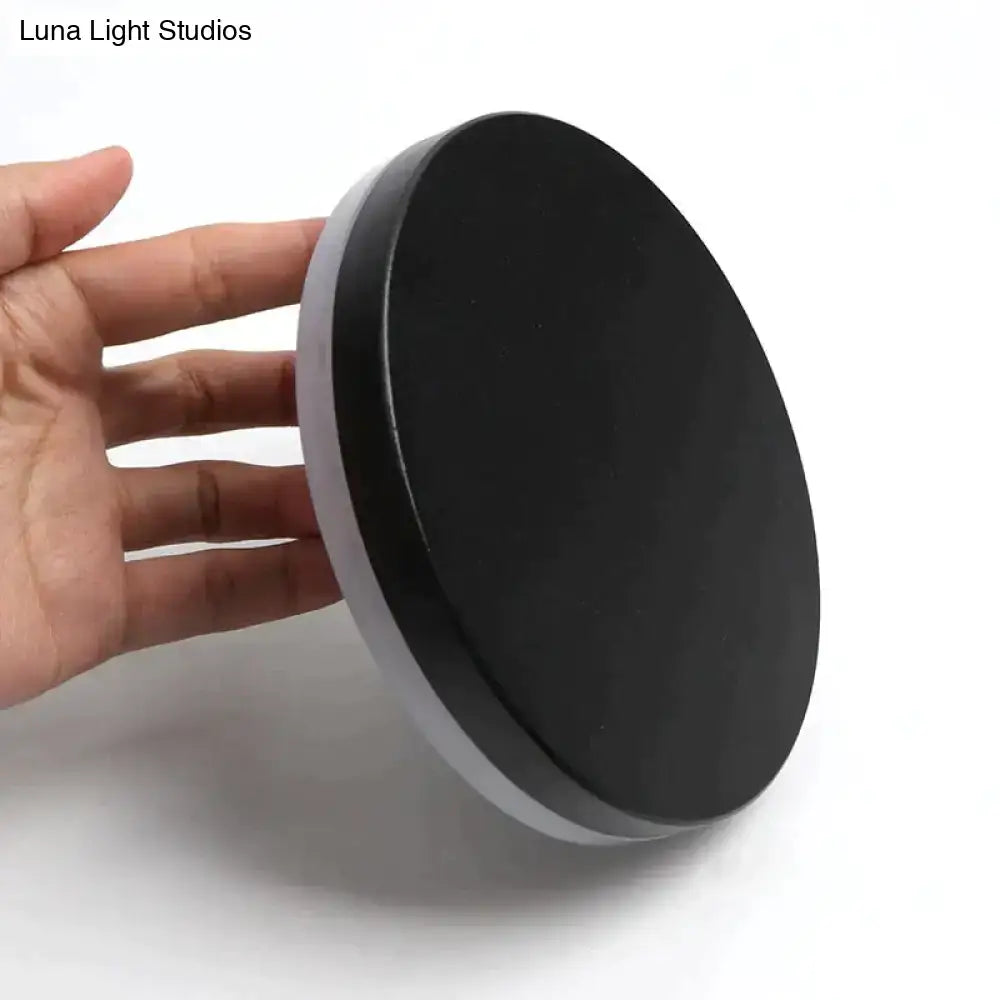 Modern black circular wall lamp with smooth matte finish and thin silver rim from a waterproof three disc bedroom set