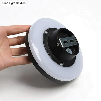 Modern black circular waterproof wall lamp with three discs featuring a sleek LED ring light and white diffuser