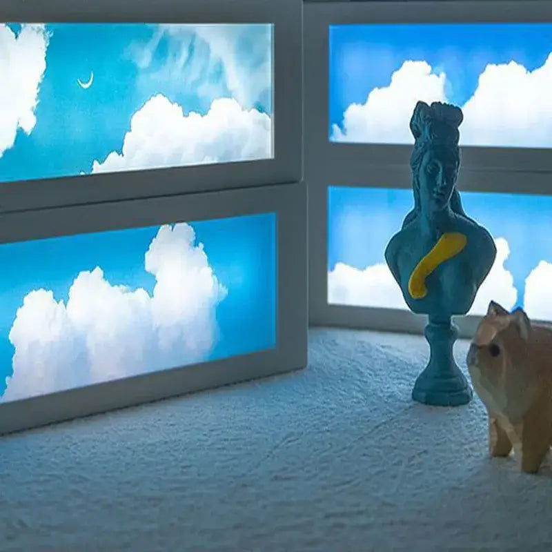 Modern black cloud night light decor features a blue sculpted bust with yellow accent standing on a pedestal