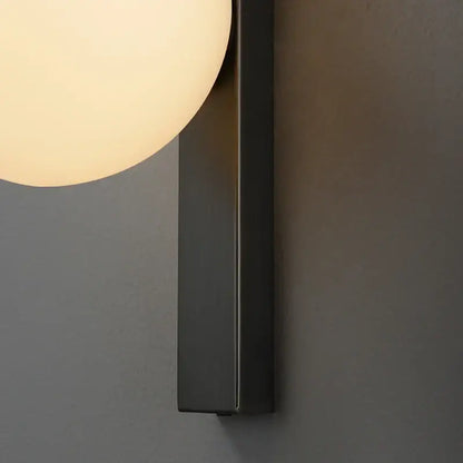 Modern black copper wall sconce featuring a matte black rectangular base with a warm frosted glass globe for decorbites black copper
