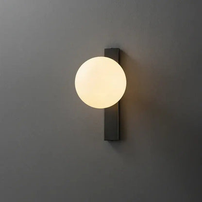Modern black copper wall sconce with frosted glass globe emitting warm light ideal for bedroom decorbites black copper estiluz