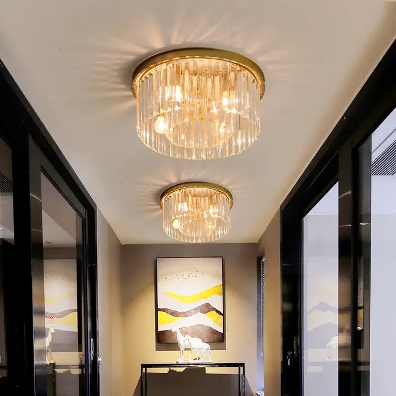 Modern black crystal flush mount ceiling light features a gold-toned crystal chandelier with clear glass rods and warm lighting
