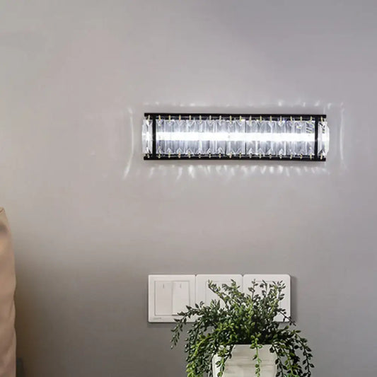 Modern black crystal rectangular sconce with clear crystal accents designed as a bedroom wall light fixture