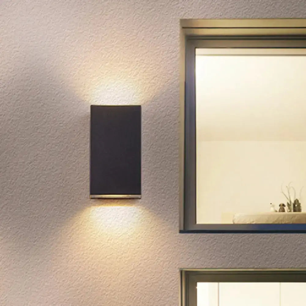 Modern black cube led wall sconce with sleek metallic base emitting warm ambient light for 110v-120v or 220v-240v use