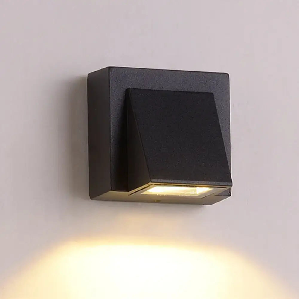 Modern black cube led wall sconce with matte finish and angled design emitting warm yellow light for 110v-120v use