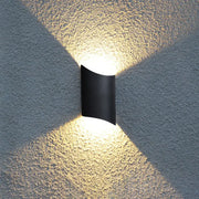 Modern black curved led wall lamp emitting warm directional light for yard outdoor use as a stylish wall lamp