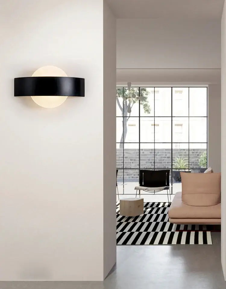 Modern black curved led wall light with minimalist design and circular frosted glass diffuser for kitchen and dining