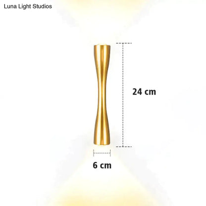 A sleek gold-toned metallic floor lamp 24 cm tall with a slender hourglass design for modern indoor use
