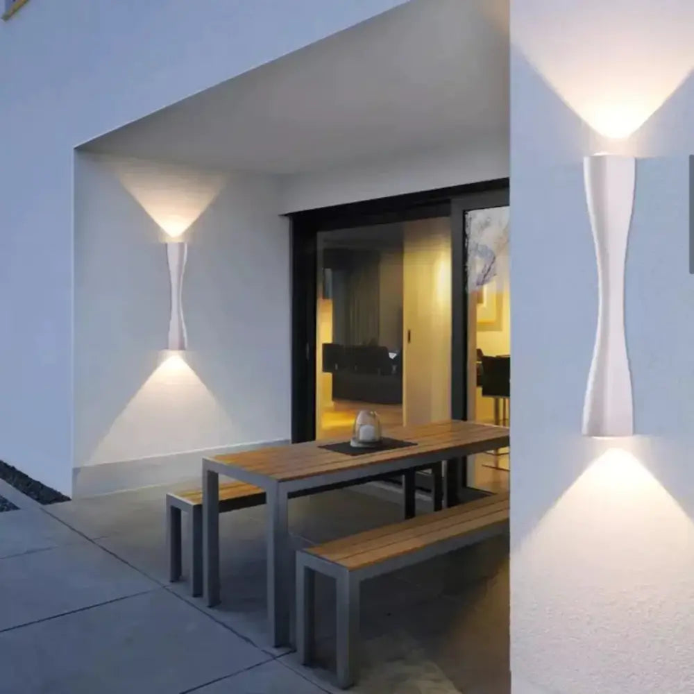 Modern black curved wall sconce with sleek design casting warm light for outdoor waterproof porch lighting