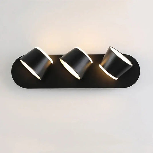 Modern black decorbites adjustable led wall lamp with three cylindrical light heads emitting warm white illumination