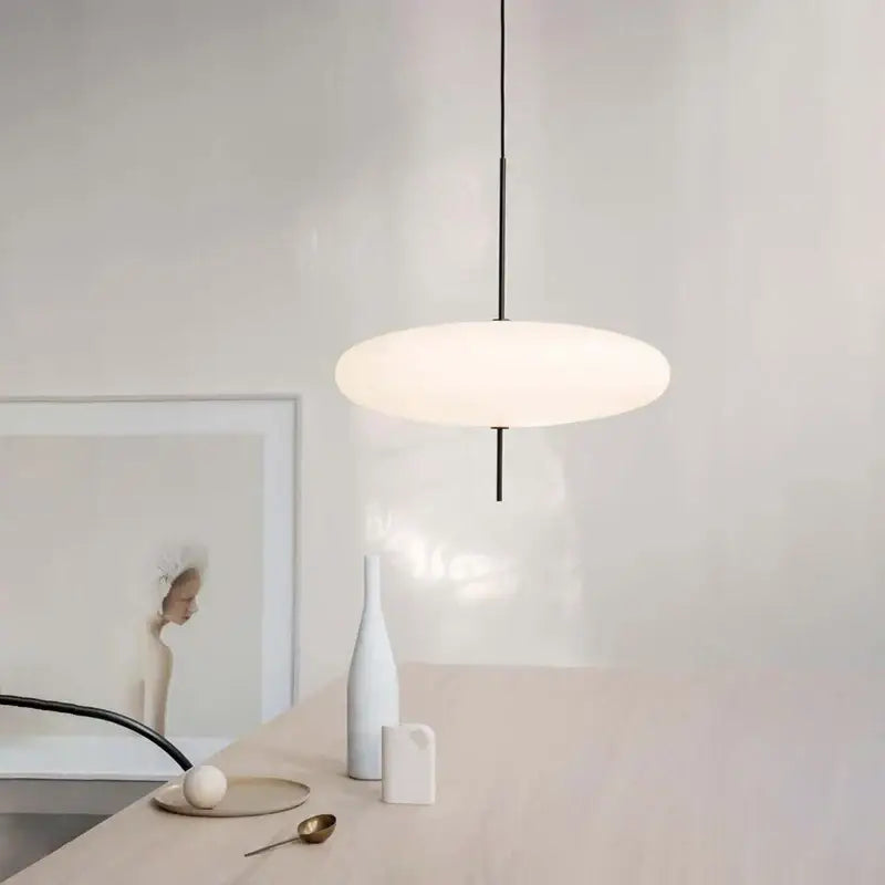 Minimalist modern black designer iron pendant light with a sleek rod and frosted glass shade for dining room decor