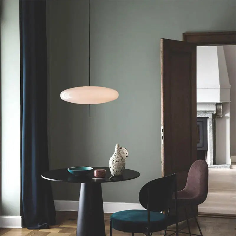 A sleek oval pendant light with off-white glass shade for dining room by decorbites designer iron pendant