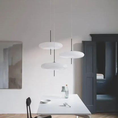 Modern white disc-shaped pendant light with black slender cords by decorbites designer iron for dining room and bar decor