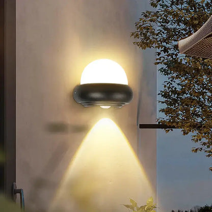 Modern black dome led wall light with a warm circular solar-powered design and frosted glass diffuser for outdoor use