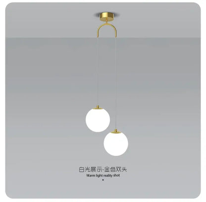 Gold-toned ceiling-mounted pendant light with double glass ball white shades for modern bedroom lighting