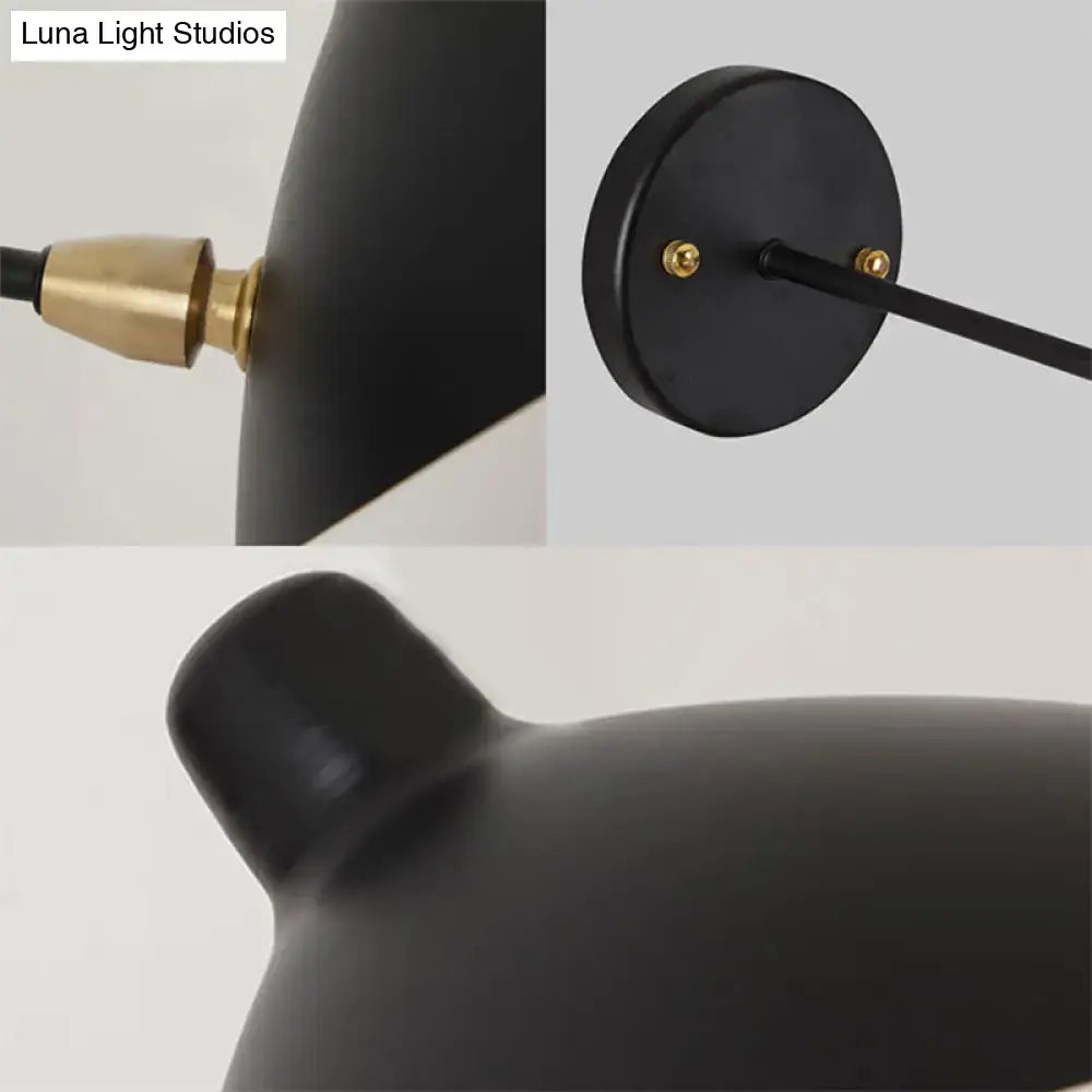 Modern black wall lamp with duckbill shade and brass accents featuring a curved arm for bedroom use
