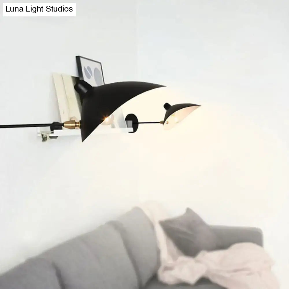Modern black wall lamp with duckbill shade, curved arm, adjustable light heads, and brass accents for bedroom use