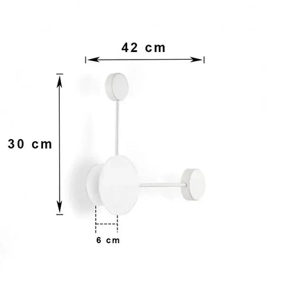 Minimalist white wall-mounted coat rack with three circular hooks paired with modern black geometric led wall lamp