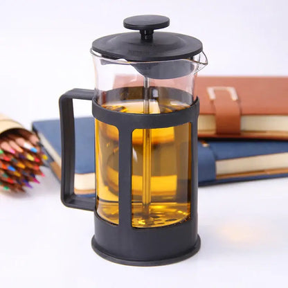 Modern black glass 350ml plastic coffee french press with black frame filled with golden brown brewed tea